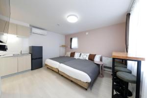 a small bedroom with a bed and a kitchen at わっず福住 in Tsukisappu