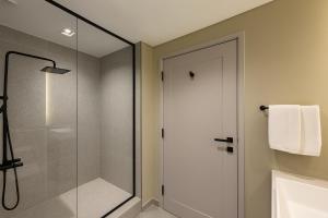 a bathroom with a shower and a glass shower door at Burj Khalifa View Studio - 10 mins away Dubai Mall in Dubai +2 photos
