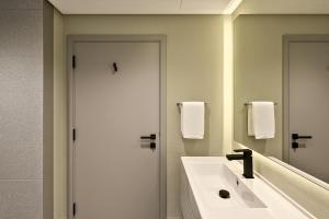a bathroom with a white sink and a mirror at Burj Khalifa View Studio - 10 mins away Dubai Mall in Dubai