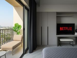 a bedroom with a bed and a tv and a balcony at Burj Khalifa View Studio - 10 mins away Dubai Mall in Dubai