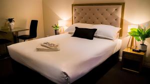 a bedroom with a large white bed with towels on it at Manjimup Gateway Hotel in Manjimup