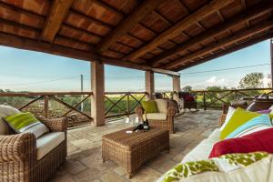 an outdoor patio with wicker furniture and a view at Torre di Baratti Bio Resort in Populonia