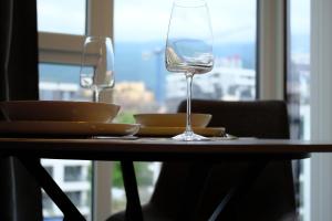 ein Tisch mit einem Weinglas und Tellern darauf in der Unterkunft Eleve Residences - Obsidian Studios in Sofia