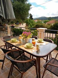 uma mesa com tigelas e pratos num pátio em Maniata Holiday Apartments em Andipáta Erísou