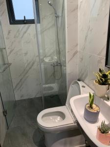 a bathroom with a shower and a toilet and a sink at 2 bedrooms apartment with free swimming pool, BBQ in Dĩ An