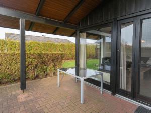 un tavolo di vetro appoggiato su un patio in una casa di Ferienhaus J7 a Butjadingen