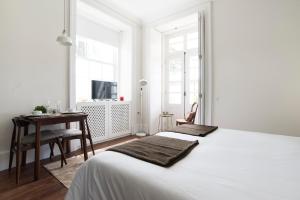 a bedroom with a white bed and white walls at bnapartments Carregal in Porto