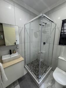 una doccia con box in vetro in un bagno di Durban Holiday Apartments by Mieli Estates , Unit 2 a Durban