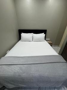 un letto con lenzuola e cuscini bianchi in una stanza di Durban Holiday Apartments by Mieli Estates , Unit 2 a Durban Altre 31 foto