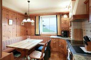 a kitchen with a wooden table and a window at DieAussicht - Refugium am Berg in Hippach