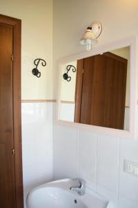 a bathroom with a sink and a mirror at Residence Giuly Rosselmini in Pieve di Santa Luce