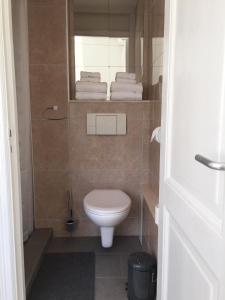 a bathroom with a toilet and a mirror and towels at Studio De Laan in Zandvoort