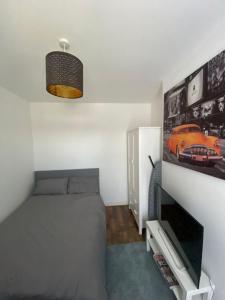 Un dormitorio con una cama y un televisor en una pared. en Zukz Haven, en Luton