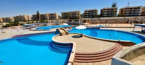 une grande piscine avec de l'eau bleue dans une ville dans l'établissement Villa Hana green beach, à El Alamein