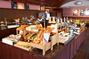 a buffet line with different types of bread and pastries at Kobe Sannomiya Tokyu REI Hotel in Kobe