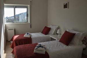 a hotel room with two beds and a window at Apartamento Viana Vista in Viana do Castelo