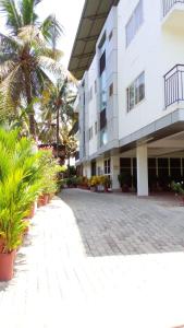 a building with palm trees in front of it at Indeevaram Residency in Trivandrum