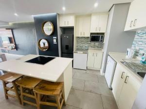 a kitchen with white cabinets and a white counter top at Beachy Seaside Serenity in Umdloti