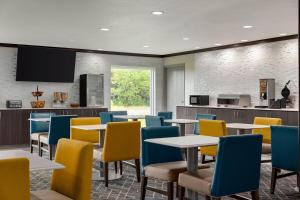 a dining room with tables and chairs and a tv at La Quinta Inn & Suites by Wyndham Peru Starved Rock St Park in Peru
