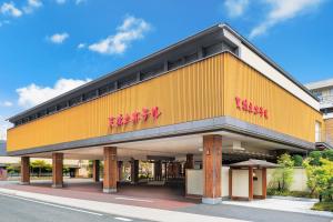 un edificio giallo con una scritta rossa sopra di Amano Hashidate Hotel a Miyazu
