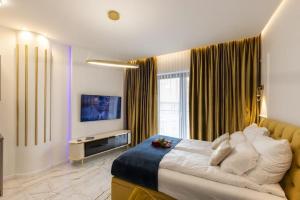 a bedroom with a large bed and a television at Hanza King Apartament 2 and SPA in Szczecin
