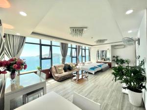 ein Wohnzimmer mit Sofa und Tisch in der Unterkunft Pearl Nha Trang Beach Apartment in Nha Trang