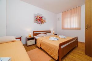 a bedroom with two beds and a window at Apartments and rooms Bionda in Senj