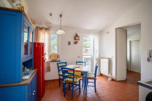 a kitchen with blue cabinets and a table and chairs at Casa Vacanze Pinuccia in Corniglia