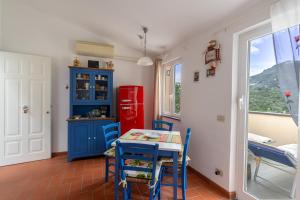 a kitchen with a table and a red refrigerator at Casa Vacanze Pinuccia in Corniglia +9 photos