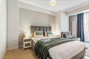 a bedroom with a large bed and a chair at Scorpios in Infinity Pool & Spa Resort in Mamaia Sat/Năvodari