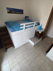 una camera da letto con un letto bianco con una coperta blu di Thalassa Beach House, Marathonas-Aegina a Kapótidhes Altre 10 foto