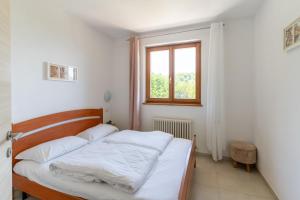 a bedroom with a bed with white sheets and a window at Infinity View Garda lake in Tenno +77 photos