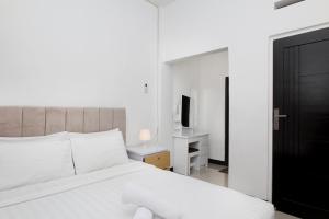 バンドンにあるVilla Normandieの白いベッドとテレビのある寝室
