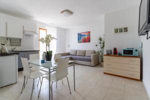 a kitchen and a living room with a table and chairs at Infinity View Garda lake in Tenno