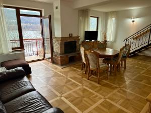 a living room with a table and a fireplace at Lake House in Alexandru cel Bun