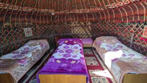 a small room with two beds in a yurt at Yurt camp KEREMET in Kyzart