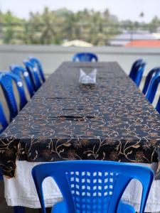 a table with blue chairs around it with a black table cloth at Indeevaram Residency in Trivandrum