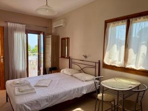 a bedroom with a bed and two chairs and a table at Artion Studios in Vourvourou