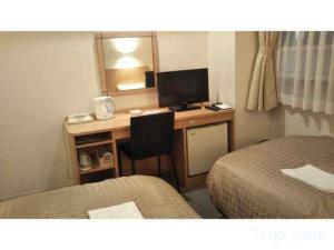a hotel room with a desk with a computer and a bed at Hiroshima Diamond Hotel in Minami-kannommachi