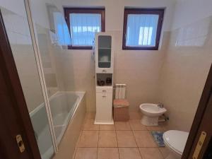 a bathroom with a shower tub and a toilet at 4-persoonsappartement met terras aan het Comomeer in Acquaseria