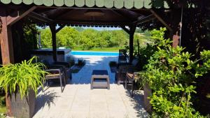 a patio with a table and chairs and a swimming pool at Residence Green Pool & SPA in Visoko