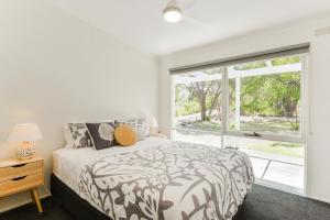 ライにあるThe Hidden Gem Family friendly home with huge backyard for kids and petsのベッドと大きな窓のある寝室