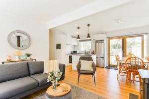 ライにあるThe Hidden Gem Family friendly home with huge backyard for kids and petsのリビングルーム(グレーのソファ付)、キッチンが備わります。