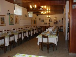 a dining room with long tables with white tablecloths at Al Caminetto in Aosta