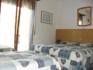 a bedroom with two beds and a mirror at Al Caminetto in Aosta