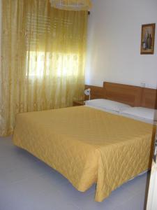 una camera da letto con un grande letto con copriletto giallo di Al Caminetto ad Aosta