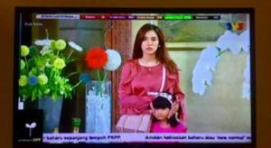 uma tela de televisão com uma mulher e uma criança nela em RAINFOREST Budget Stay em Kuching mais 72 fotografias