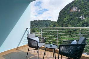 a balcony with chairs and a table and a mountain at TUI BLUE The Haven Ipoh in Ipoh