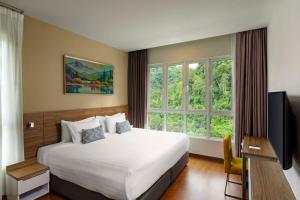 a hotel room with a bed and a large window at TUI BLUE The Haven Ipoh in Ipoh