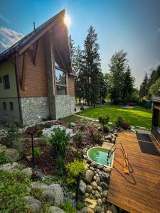 a backyard with a swimming pool and a wooden deck at Chalet Vista Biohacking & Jacuzzi Recovery Chalet in Belá